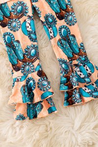 Pair of leggings with a blue and bronze pattern on a fluffy white surface