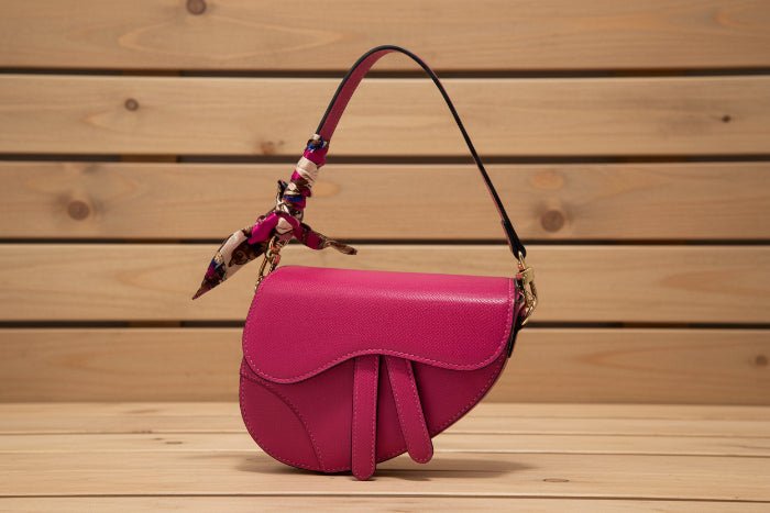 Pink handbag with a floral-patterned scarf on barn background