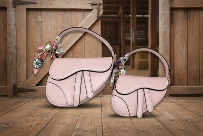 Pink handbag with decorative scarf on a wooden background