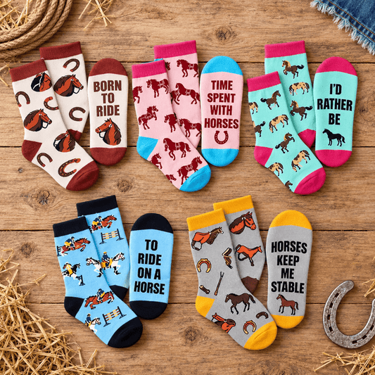 Six pairs of western-themed socks arranged on a rustic wooden surface with straw and denim props. The socks feature horse illustrations and phrases like 'BORN TO RIDE,' 'TIME SPENT WITH HORSES,' 'I'D RATHER BE,' 'TO RIDE ON A HORSE,' 'HORSES KEEP ME STABLE,' and 'DON'T BE A SADDLE.