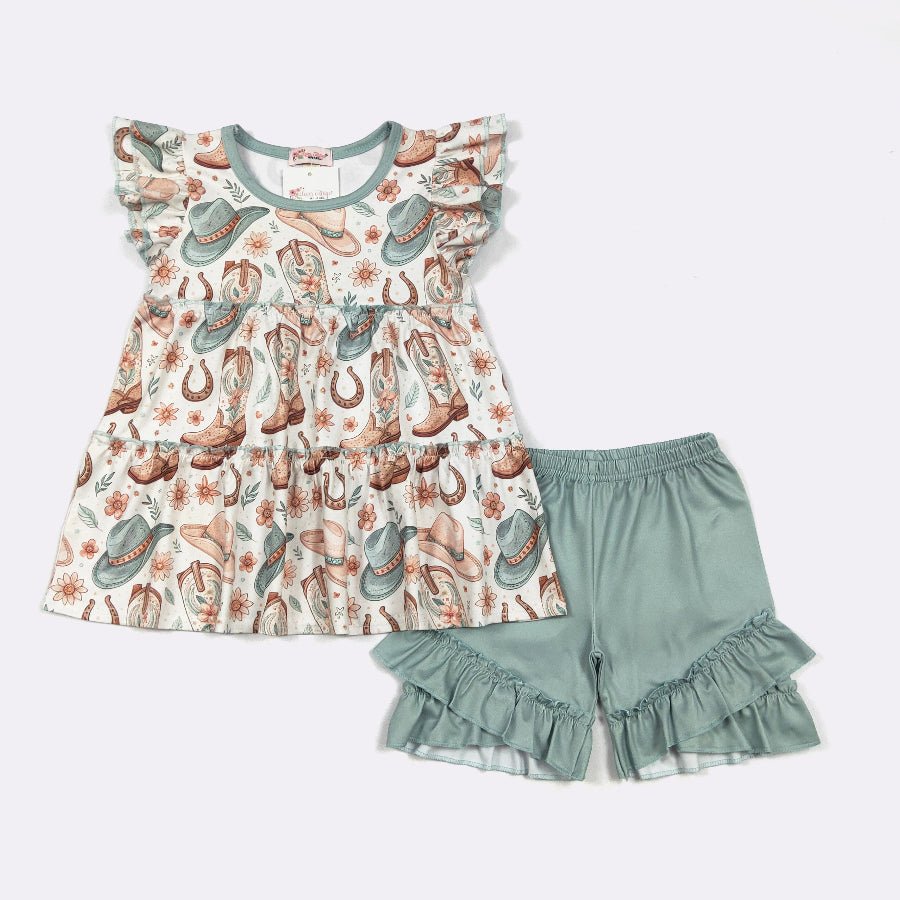 Children's outfit with floral cowgirl top and green shorts on a white background