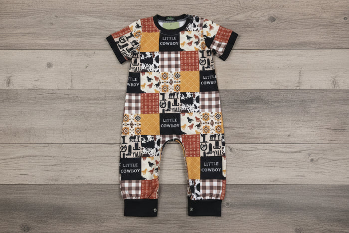 Baby romper with cowboy-themed pattern on a wooden background
