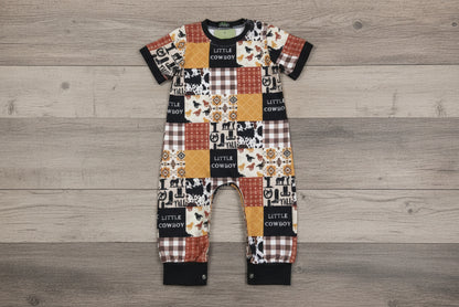 Baby romper with cowboy-themed pattern on a wooden background