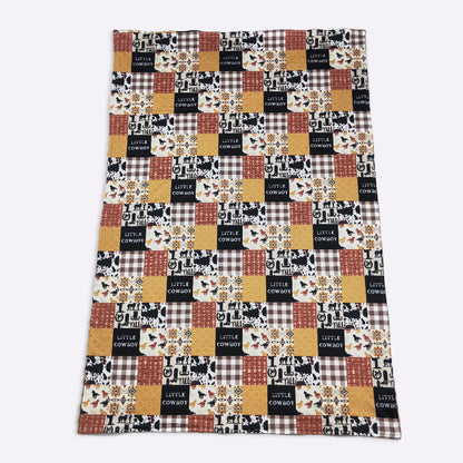 Patchwork blanket with 'Little Cowboy' text and plaid patterns on a white background