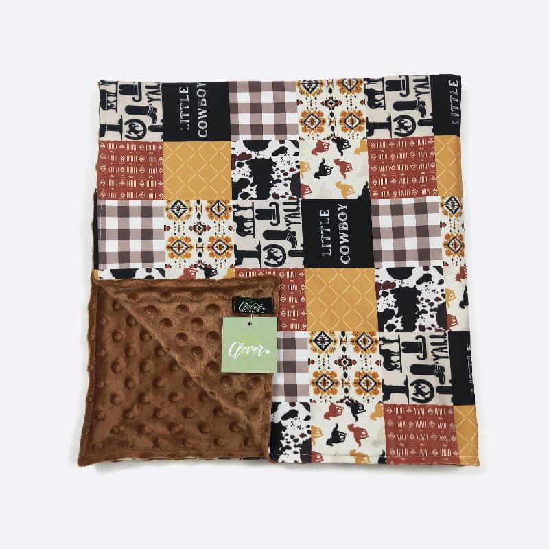 Patchwork blanket with cowboy-themed patterns on a white background