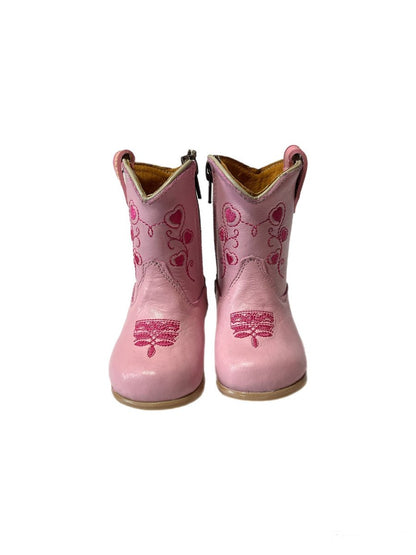Pair of pink cowboy boots with heart designs on a white background