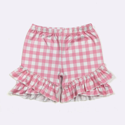 Pink and white checkered shorts with ruffled edges on a light pink background