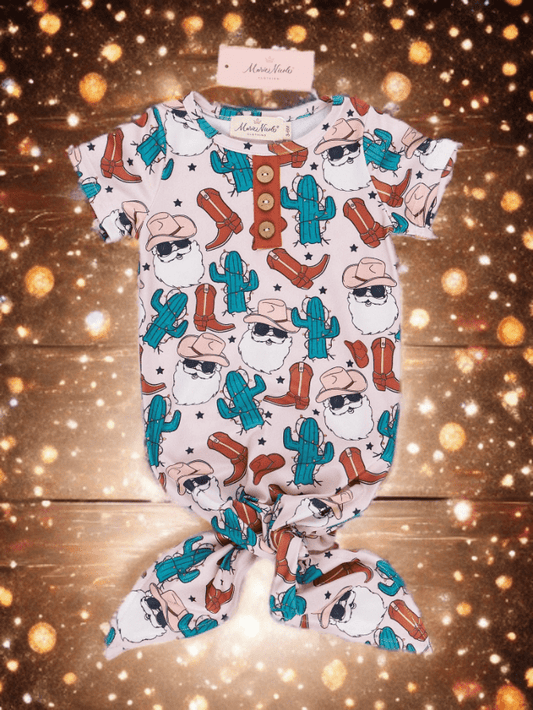 Christmas baby romper with cowboy and cactus pattern on a wooden surface