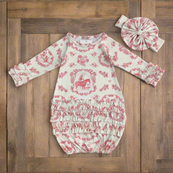 Baby romper with pink floral and horse pattern and matching headband on a wooden board background