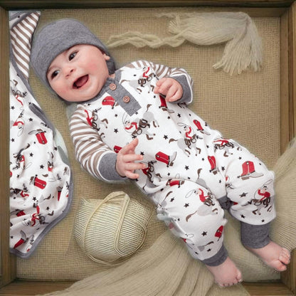 Baby laying in bamboo cowboy romper with hat and boots print
