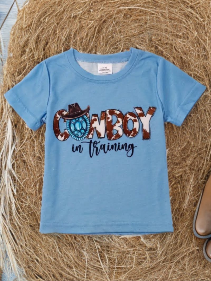 Blue cowboy toddler shirt with cowboy hat and lasso graphic, western kids tee on straw background