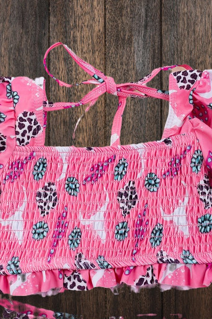 Close-up of smocked cactus print bikini top on wood