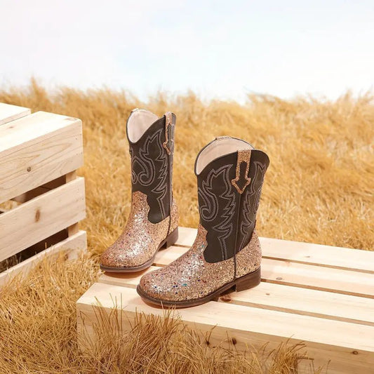 Champagne glitter cowgirl boots on straw with wood crates