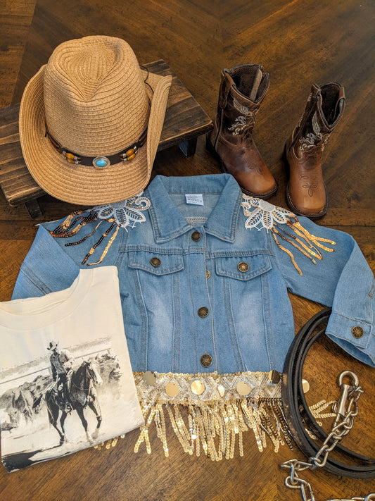 Flat lay of Glitter & Glamour Girls' Sequin Tassel Denim Jacket styled with cowboy boots, hat, and Western tee for girls.