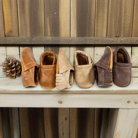 Leather newborn moccasins in Saddle, Latte, and Sable colors for baby cowboys and cowgirls
