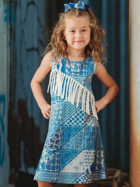Girl in blue suede fringe cowgirl dress standing by barn door