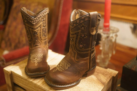 TuffRider children's Western boots with square toe design, perfect rodeo boots for kids on crate display