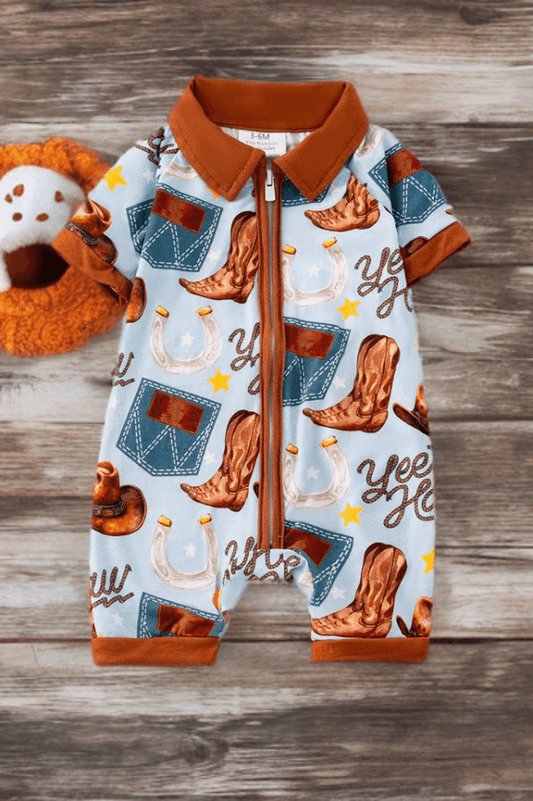 Light blue Western baby romper with cowboy boots, hats, and horseshoe print on wooden background.
