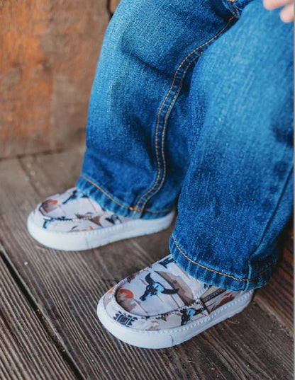 Western desert print kids sneakers paired with rolled-up denim jeans